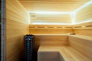 Un sauna moderne avec des murs et des bancs en bois clair